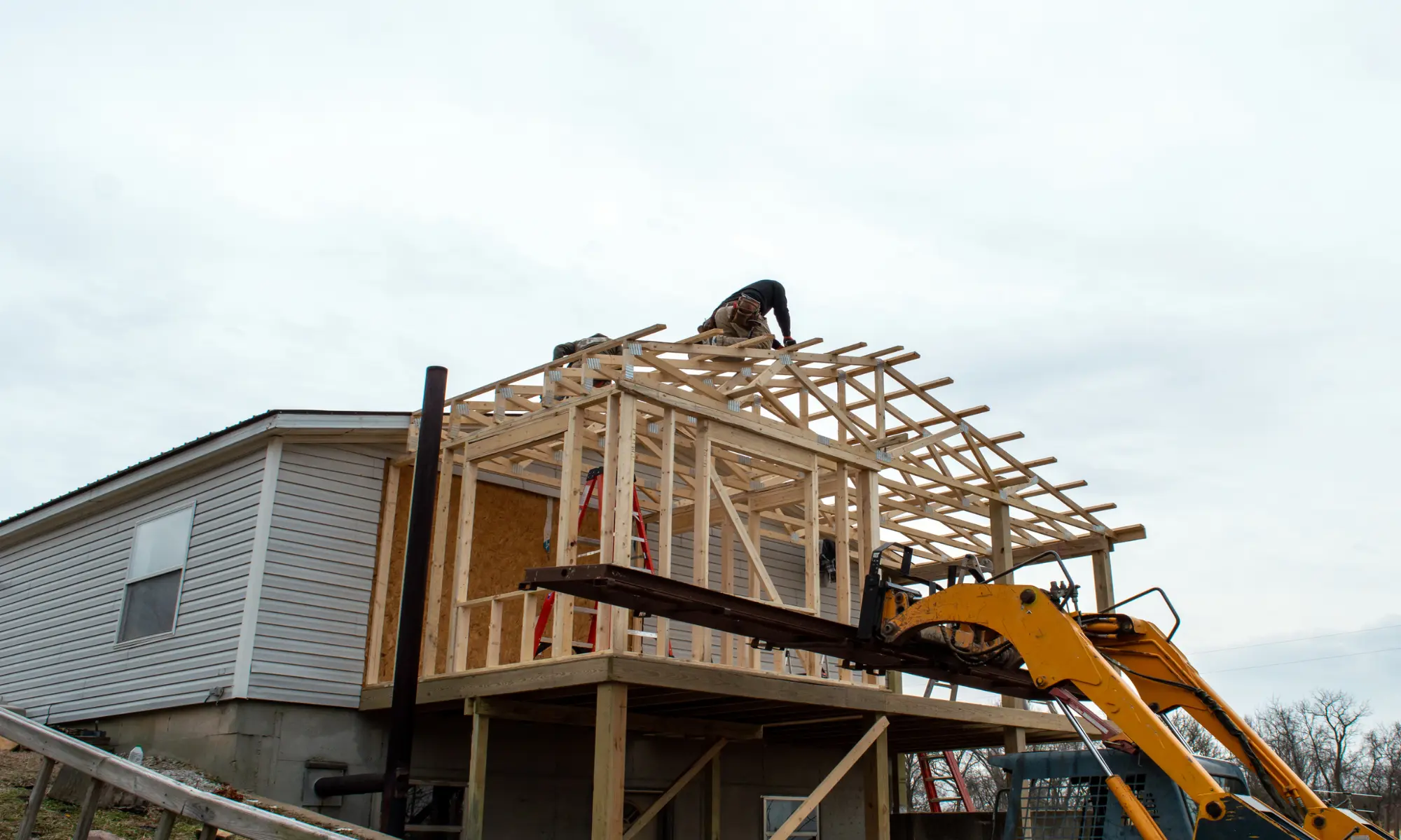 House construction with worker and machinery.