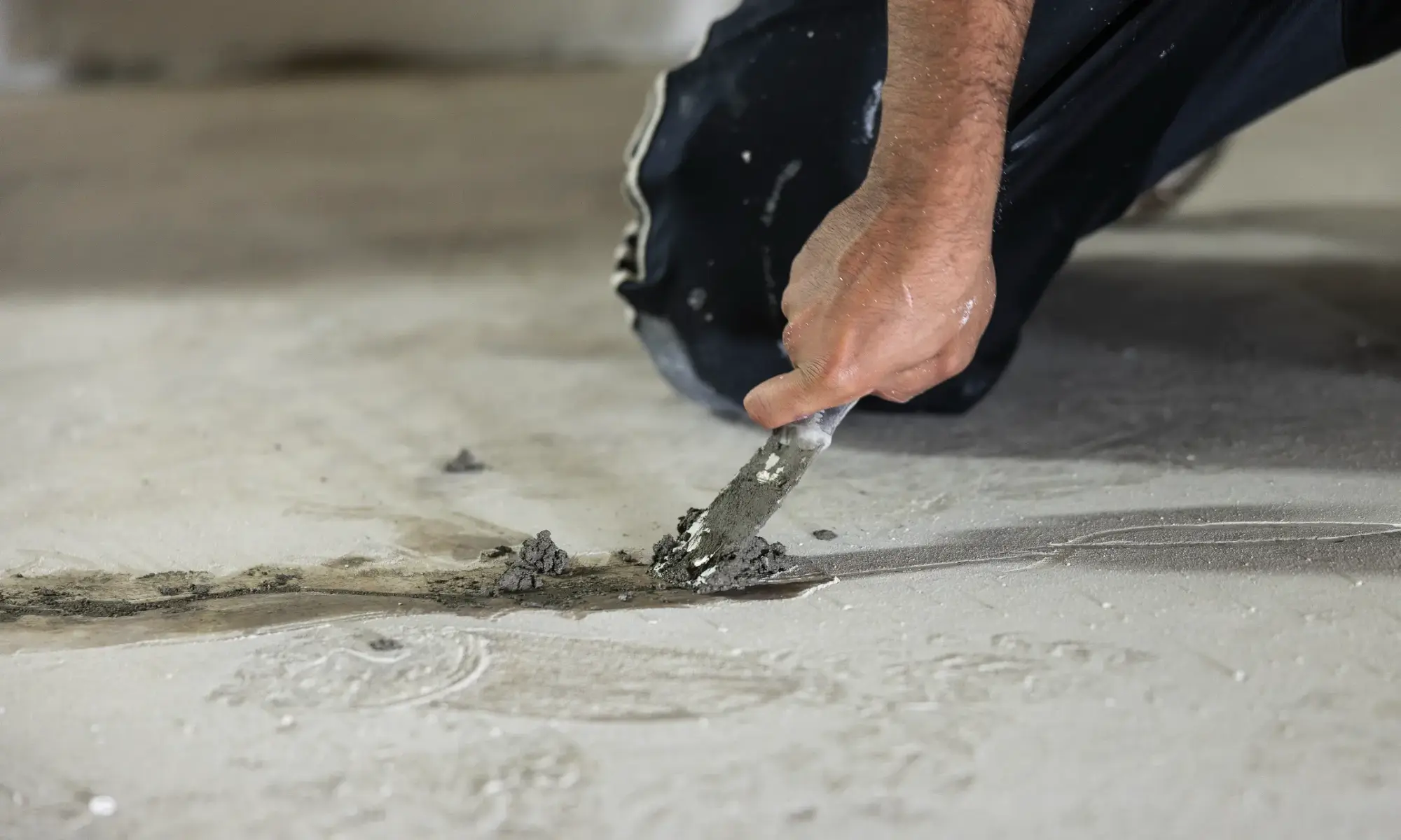 Hand applying concrete with a trowel.