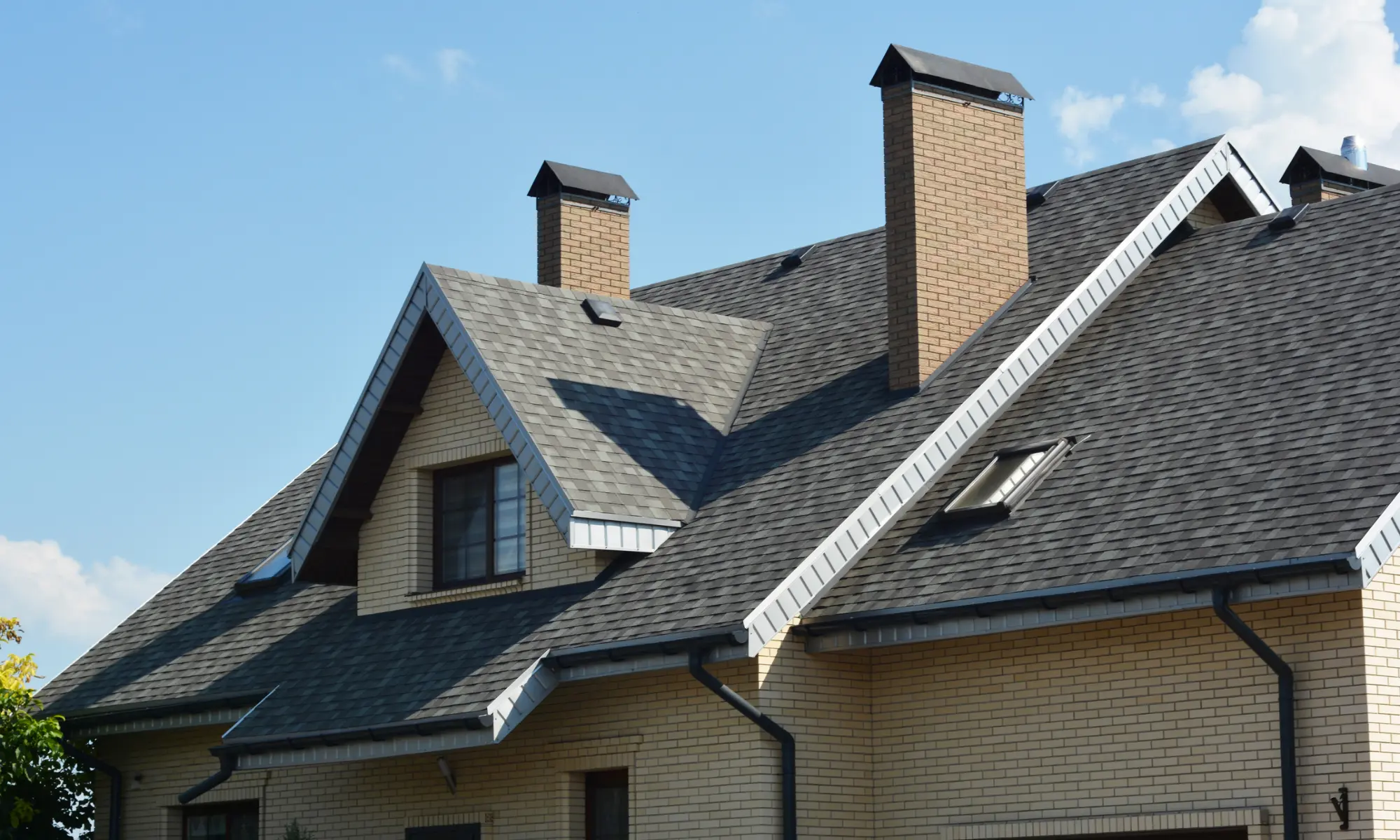 Brick house with gray shingle roof.