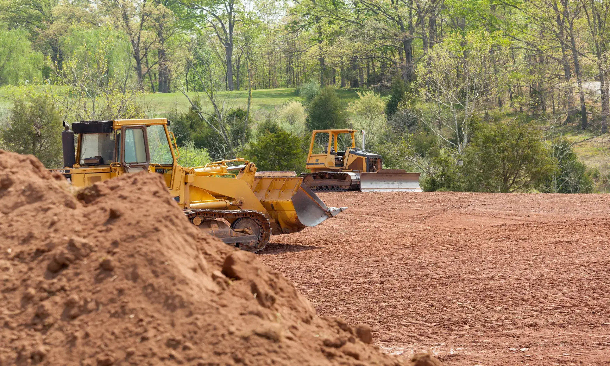 Bulldozers moving earth at construction site.