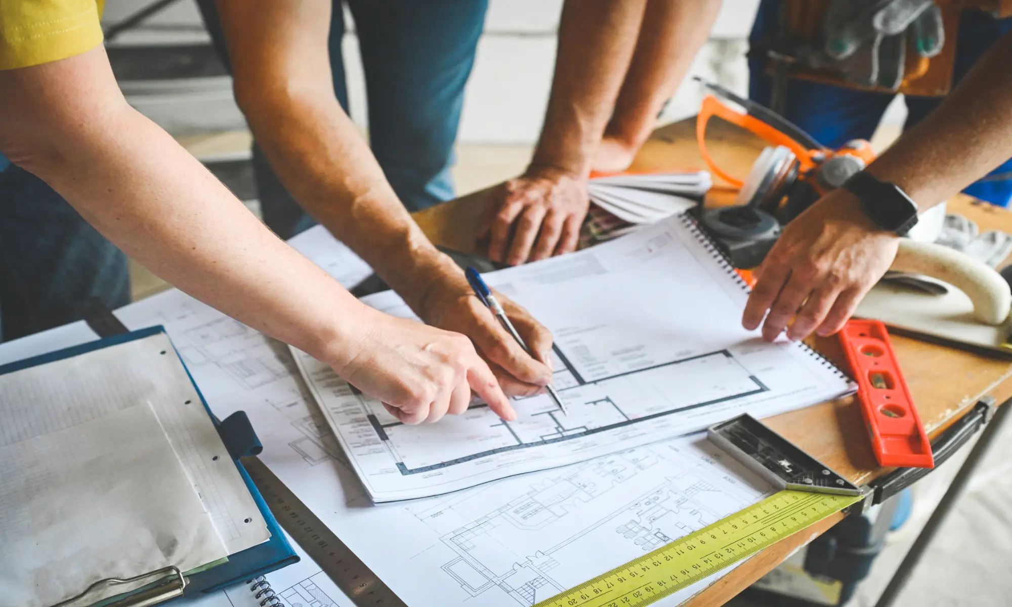 People reviewing architectural plans on table.