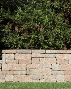 Stone retaining wall with greenery above it.