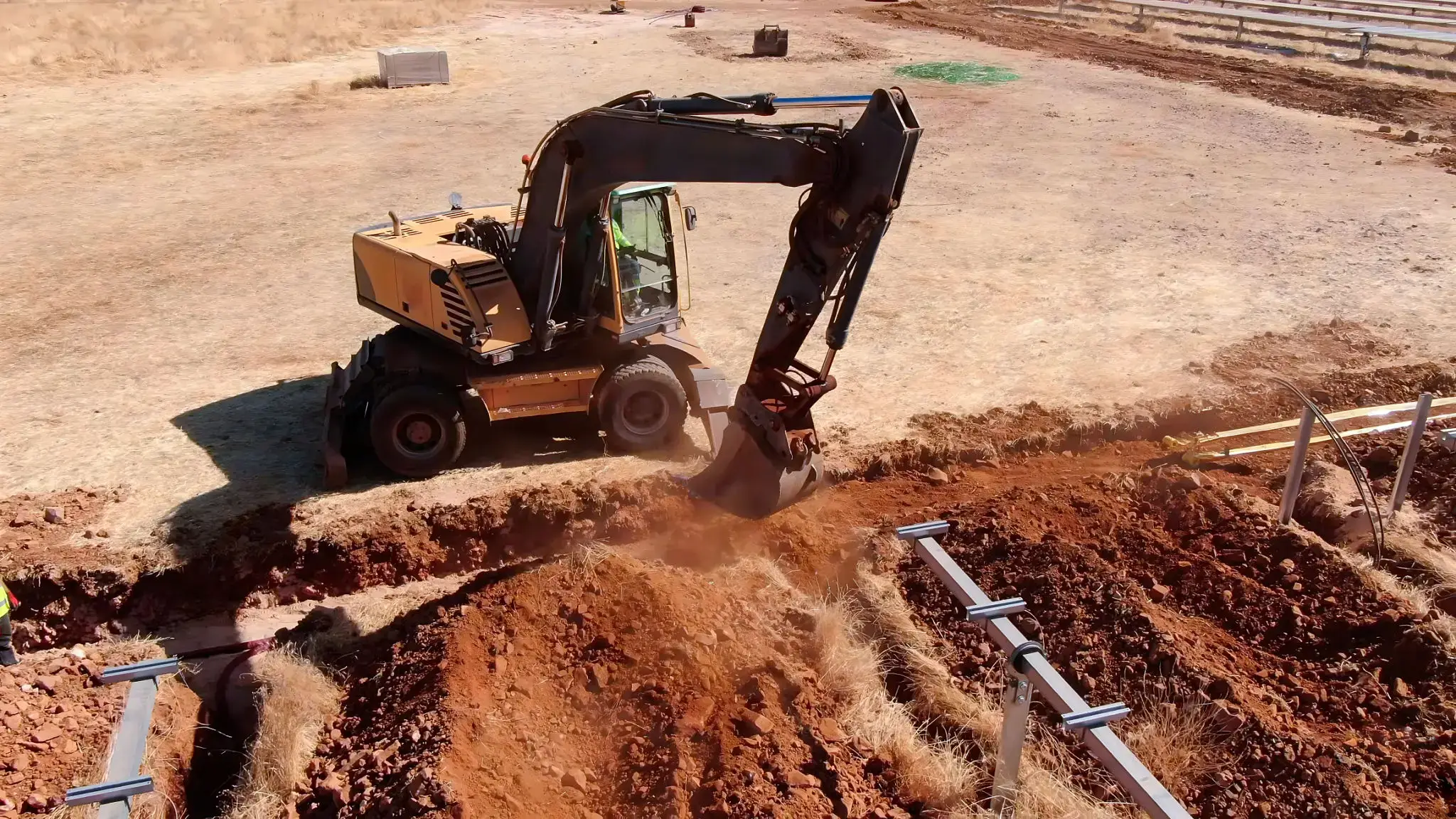 Excavator digging a trench at a construction site.